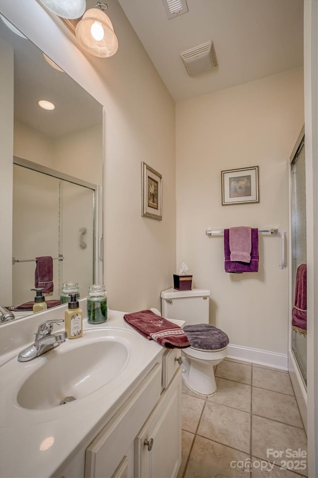 bathroom with tile patterned floors, vanity, an enclosed shower, and toilet