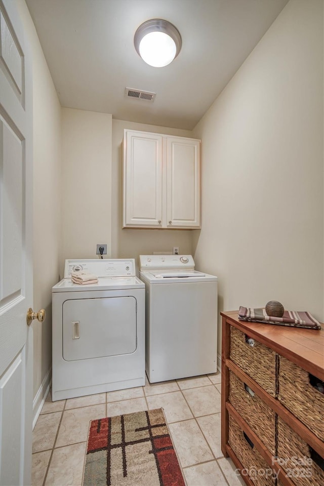 washroom featuring cabinets, separate washer and dryer, and light tile patterned floors