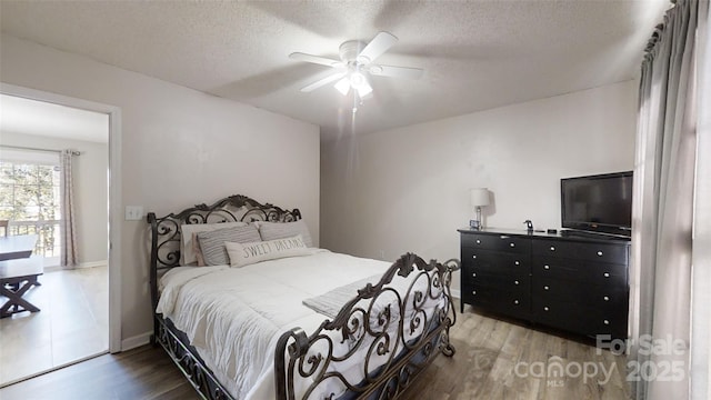 bedroom featuring hardwood / wood-style floors, a textured ceiling, and ceiling fan