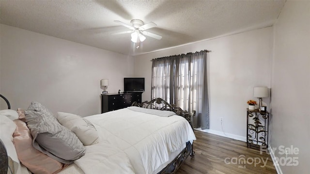 bedroom with ceiling fan, dark hardwood / wood-style flooring, and a textured ceiling