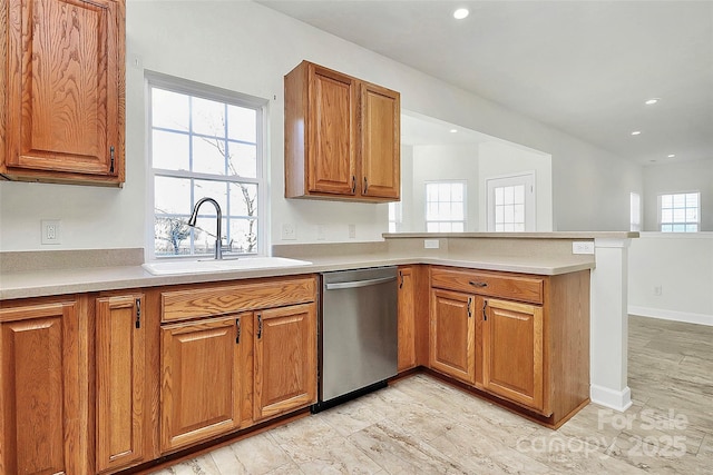 kitchen with kitchen peninsula, dishwasher, plenty of natural light, and sink