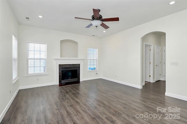 unfurnished living room featuring ceiling fan and dark hardwood / wood-style flooring