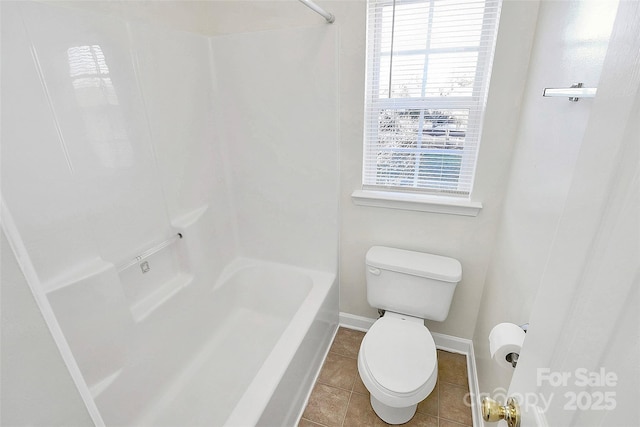 bathroom featuring tile patterned flooring, toilet, and tub / shower combination