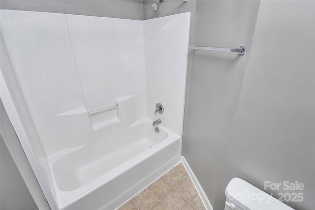 bathroom with tile patterned flooring, toilet, and shower / bathing tub combination