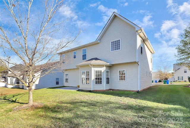 back of house with a patio and a lawn