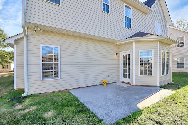 back of property featuring a lawn and a patio area