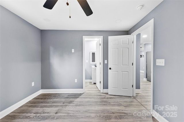 unfurnished bedroom featuring ensuite bath, ceiling fan, and light hardwood / wood-style floors