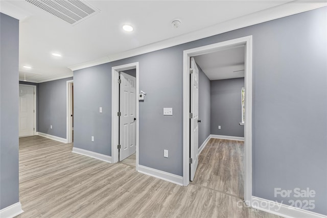 spare room featuring light hardwood / wood-style flooring and ornamental molding