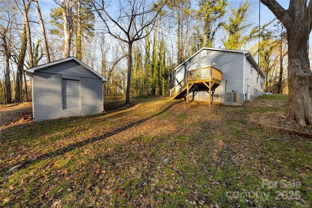 view of yard featuring a deck, an outdoor structure, and central air condition unit