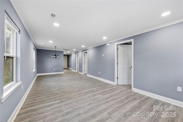 interior space with ornamental molding, a chandelier, and light hardwood / wood-style floors