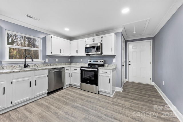 kitchen with appliances with stainless steel finishes, white cabinetry, and sink