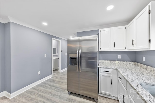 kitchen with white cabinetry, stainless steel fridge with ice dispenser, light hardwood / wood-style flooring, and light stone counters