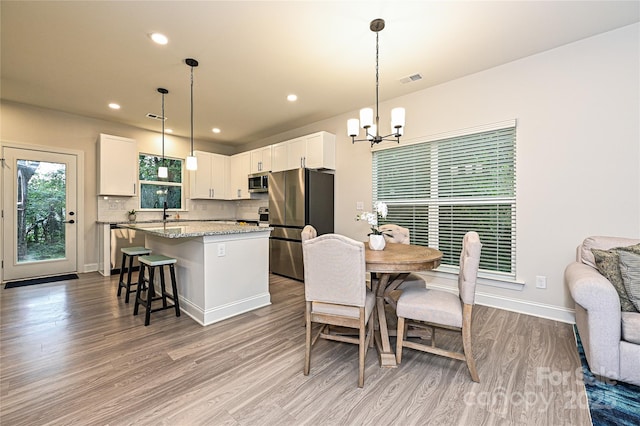 dining space featuring a chandelier, light hardwood / wood-style floors, and sink