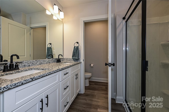 bathroom featuring vanity, wood-type flooring, and toilet