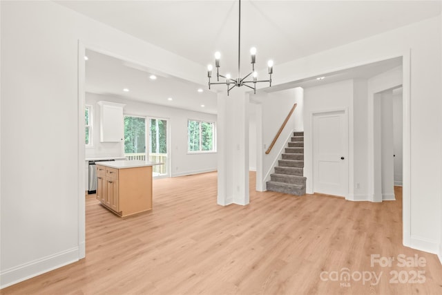 kitchen featuring light hardwood / wood-style flooring, a chandelier, a center island, white cabinetry, and hanging light fixtures