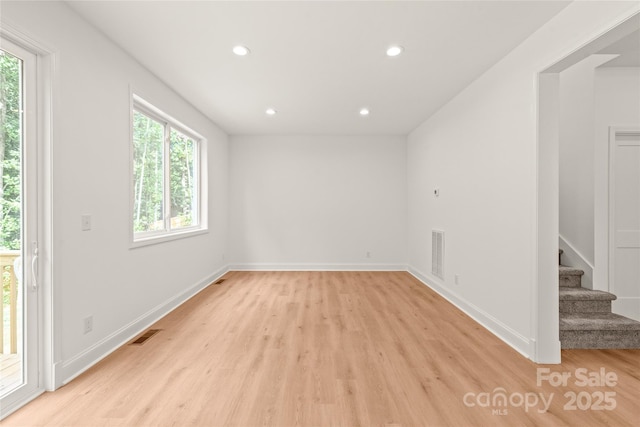 spare room featuring plenty of natural light and light hardwood / wood-style flooring