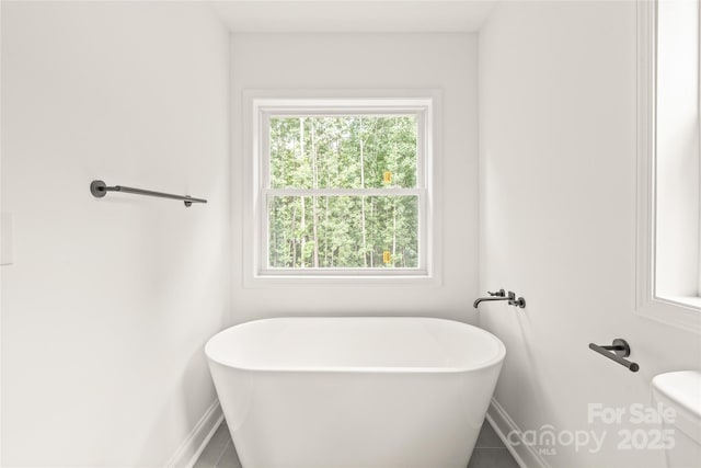 bathroom featuring tile patterned flooring and a bath