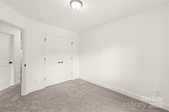 unfurnished bedroom featuring carpet flooring and a closet