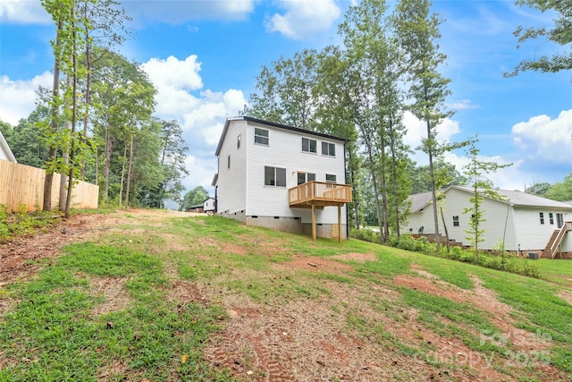 rear view of house featuring a yard and a wooden deck