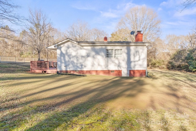 view of home's exterior with a wooden deck and a lawn