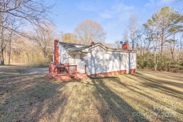 view of property exterior with a lawn and a deck