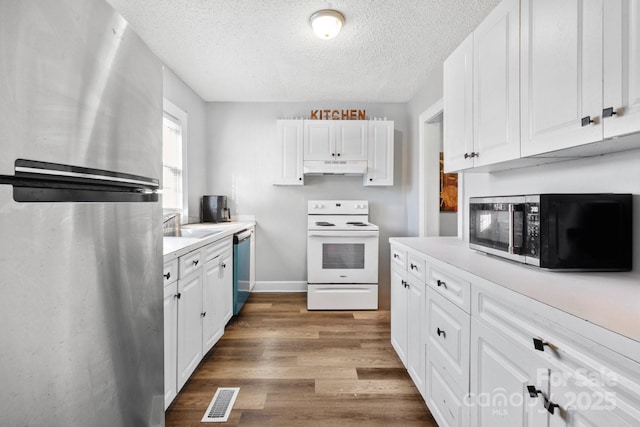 kitchen with white cabinets, dark wood-type flooring, a textured ceiling, and appliances with stainless steel finishes