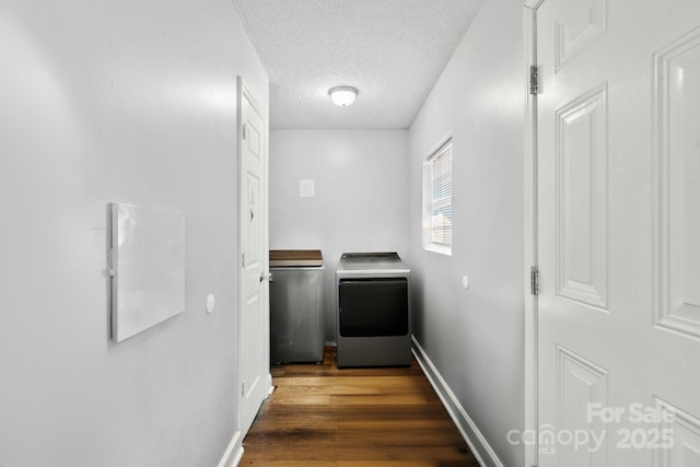 washroom with separate washer and dryer, dark wood-type flooring, and a textured ceiling