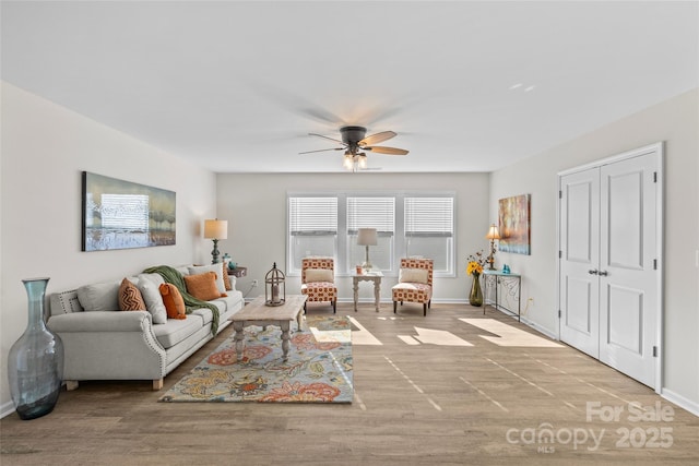 living room featuring light hardwood / wood-style flooring and ceiling fan