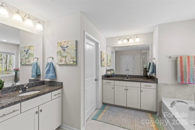 bathroom with vanity, tile patterned floors, and a bathtub