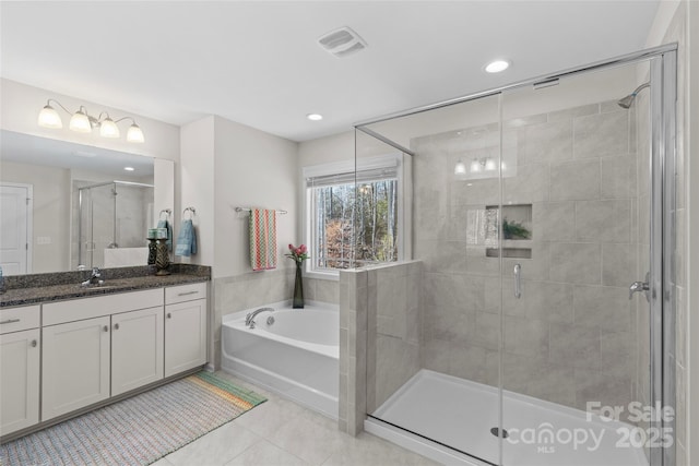 bathroom with tile patterned flooring, vanity, and separate shower and tub