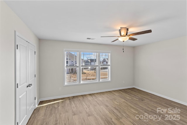 spare room with wood-type flooring and ceiling fan