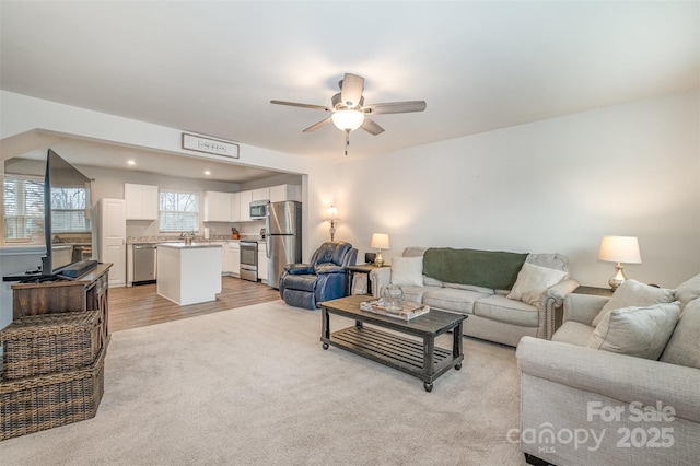 living room featuring ceiling fan and sink