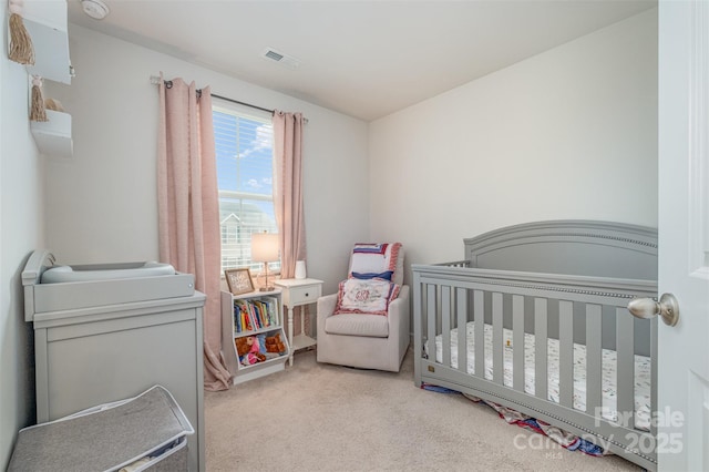 carpeted bedroom featuring a nursery area