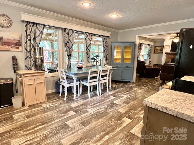 dining area featuring a textured ceiling, dark hardwood / wood-style floors, and crown molding