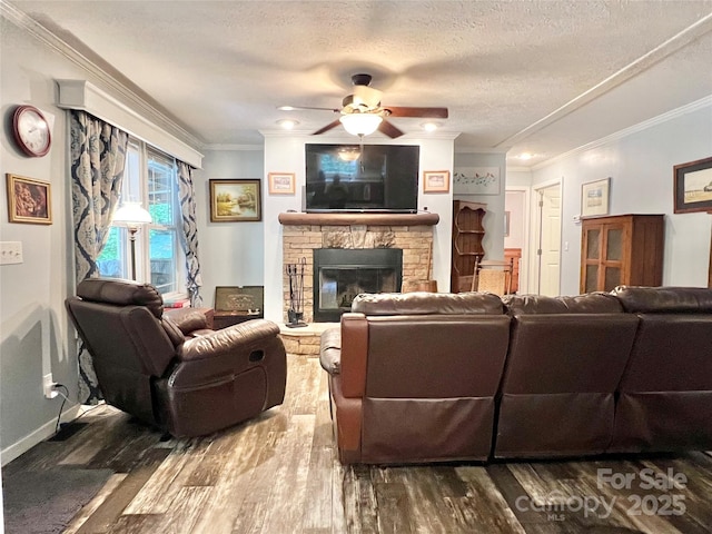 living room with a textured ceiling, a stone fireplace, crown molding, and dark wood-type flooring