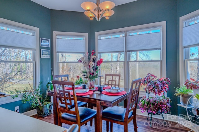 dining room with baseboards, wood finished floors, and a notable chandelier