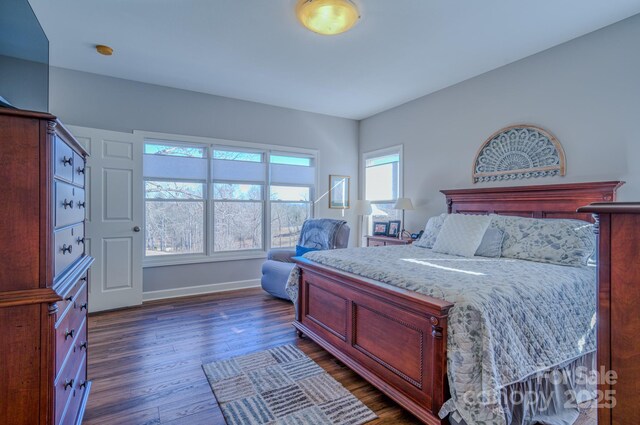 bedroom with baseboards and dark wood-style flooring