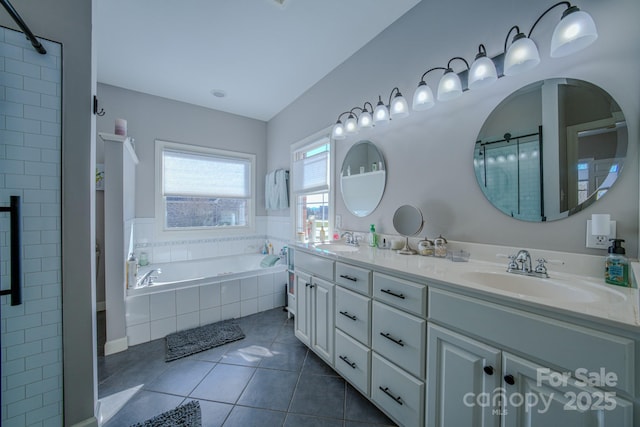 bathroom featuring a garden tub, tile patterned flooring, a sink, and a tile shower