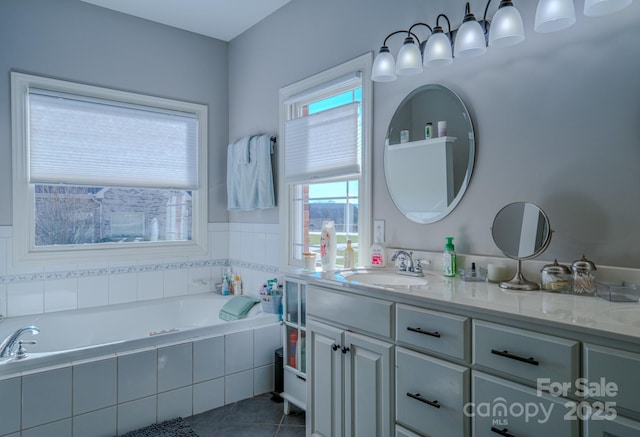 bathroom featuring a garden tub, vanity, and tile patterned floors