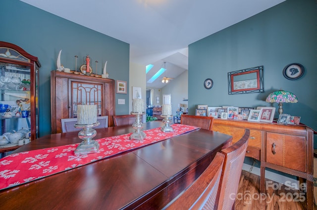 dining space with lofted ceiling and wood finished floors