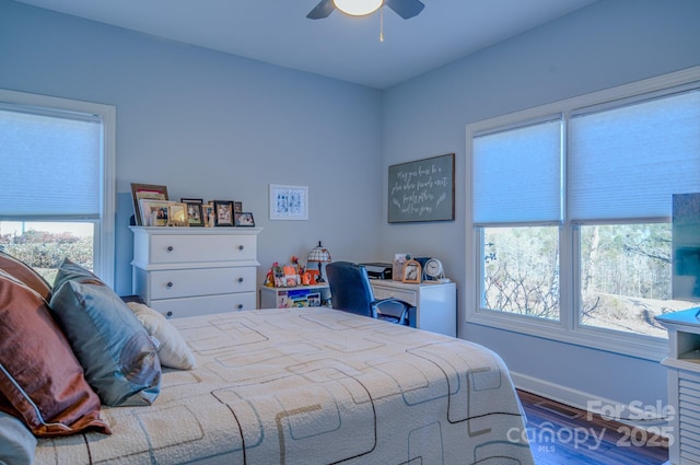 bedroom with a ceiling fan, wood finished floors, visible vents, and baseboards