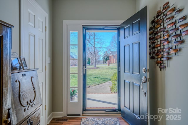 entryway with wood finished floors, visible vents, and baseboards