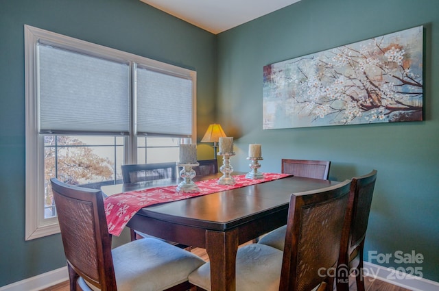 dining space with wood finished floors and baseboards