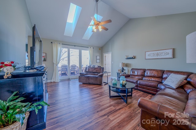 living room featuring high vaulted ceiling, a ceiling fan, wood finished floors, a skylight, and baseboards