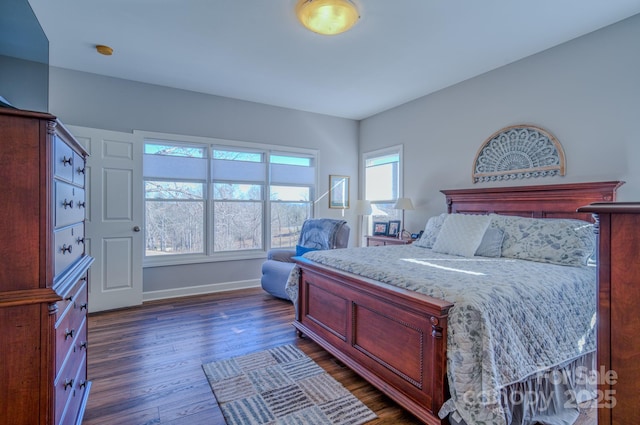 bedroom featuring baseboards and dark wood-style flooring
