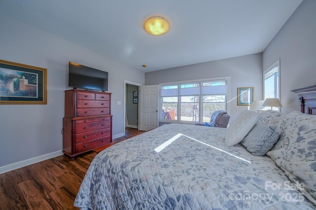 bedroom featuring baseboards, dark wood-style flooring, and multiple windows