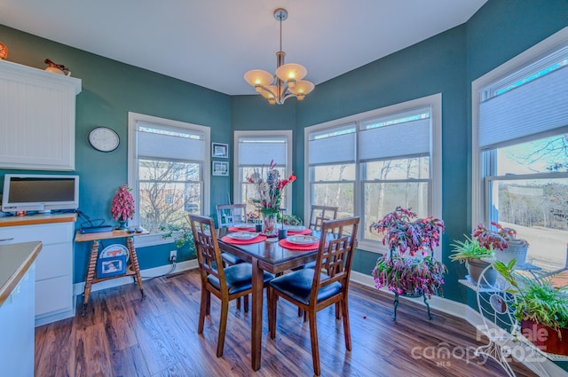 dining area with plenty of natural light, baseboards, a chandelier, and dark wood-style flooring