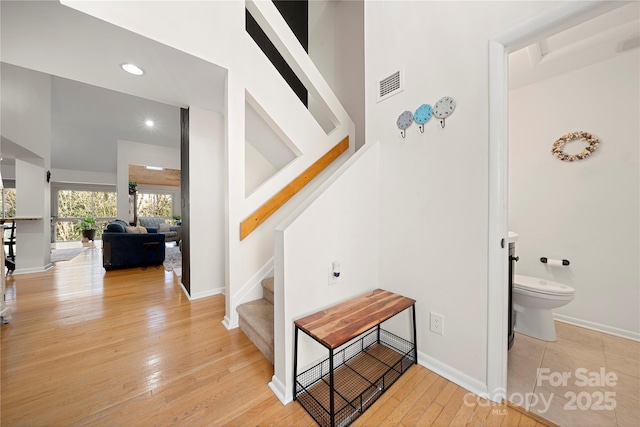 staircase featuring a towering ceiling and hardwood / wood-style flooring