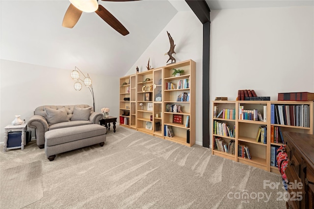 sitting room with ceiling fan, lofted ceiling with beams, and carpet flooring