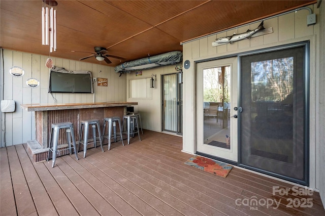 wooden terrace with ceiling fan and a bar